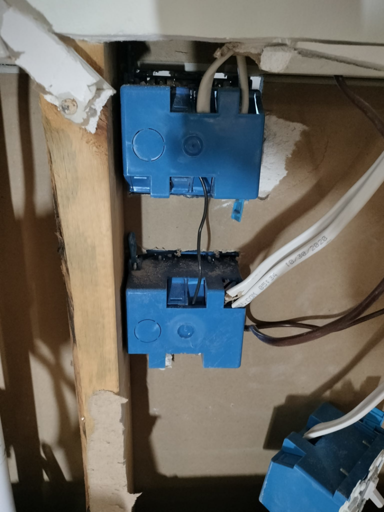 A close-up view of blue electrical boxes and wiring installed in a wall by Devin Parker Electric in Knoxville, TN