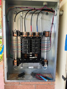 A close-up view of an open electrical breaker panel with wiring and tools, demonstrating work by Mcdaniel Electric, LLC in Waipahu, HI.