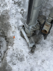 A close-up view of fence post hardware and base detail, possibly for repair, by Wayside Fences in Brattleboro, VT.