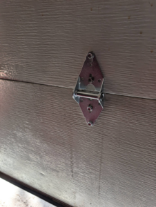 A close-up view of a garage door hinge, a common component for repair or replacement by Garage Doors & Remodeling LLC in Blue Springs, MO