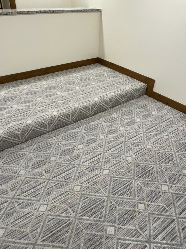 Close-up of geometric pattern carpet professionally installed on stairs by Flooring Liquidator in Orem, UT.