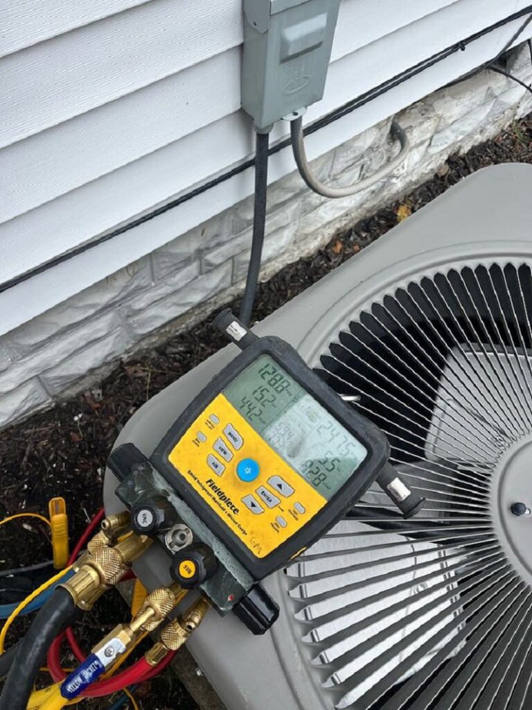 Close-up of HVAC gauges connected to an outdoor AC unit during diagnostic service by Allegiance Heating & Air in Greenville, IN.