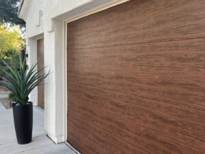 A close-up view of a modern wood-look garage door installed by Stapley Action Garage Door in Mesa, AZ.