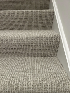 Close-up view of a freshly installed patterned carpet on a residential staircase by Creative Carpet Solutions LLC in Houston, TX.
