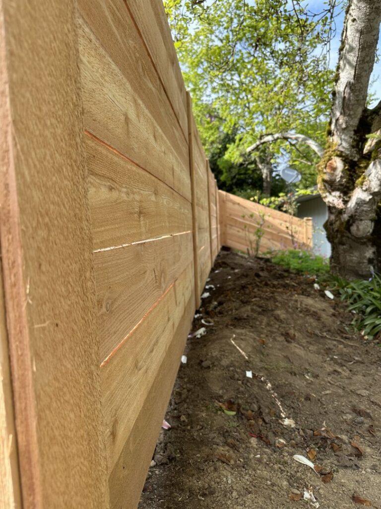A close-up view of a newly installed wood fence extending into the distance by FJ'S Fencing & Construction, LLC in Lake Oswego, OR.