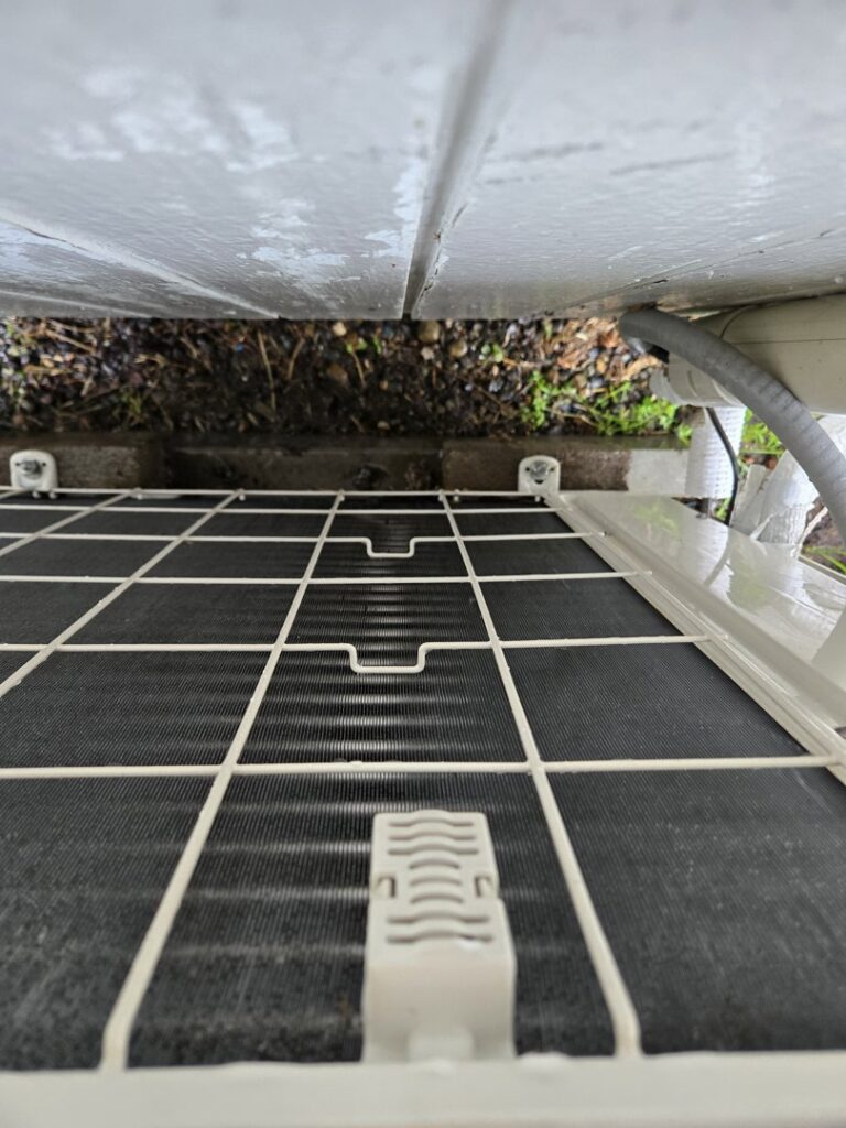A close-up view of the clean coils and fins of an outdoor HVAC unit during an inspection by Sound Comfort Heating & Air Conditioning in Everett, WA.