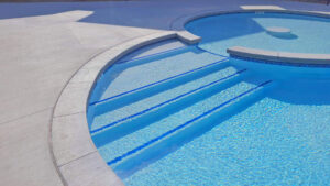 A close-up of pool steps with blue tile accents by Midwest Custom Pools, LLC in Lawrence, KS.