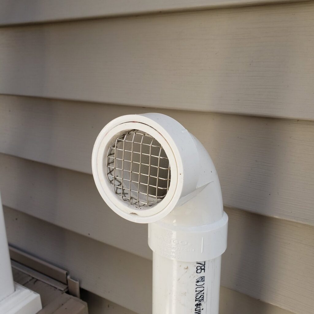 A close-up view of a PVC vent cap with a screen, part of an HVAC system installed by A-OK Heating & Cooling in Concord, GA.