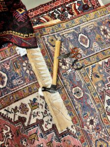 Close-up of a detailed rug repair in progress with tools at Bijar Oriental Rugs, a carpet contractor in Atlanta, GA.