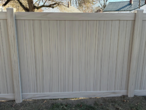 A close-up view of a tan vinyl fence panel showcasing its texture and quality, installed by H&M Fencing LLC in Decatur, IN.