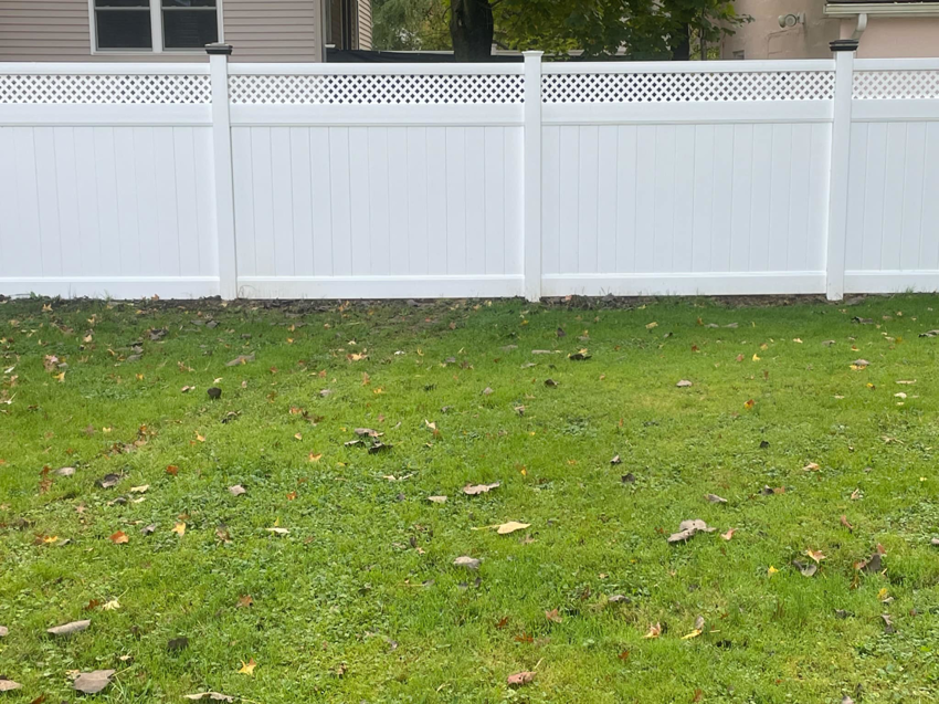 A close-up view of white vinyl fence panels with a decorative lattice top installed by Fence Guys INC in Cleveland, OH.