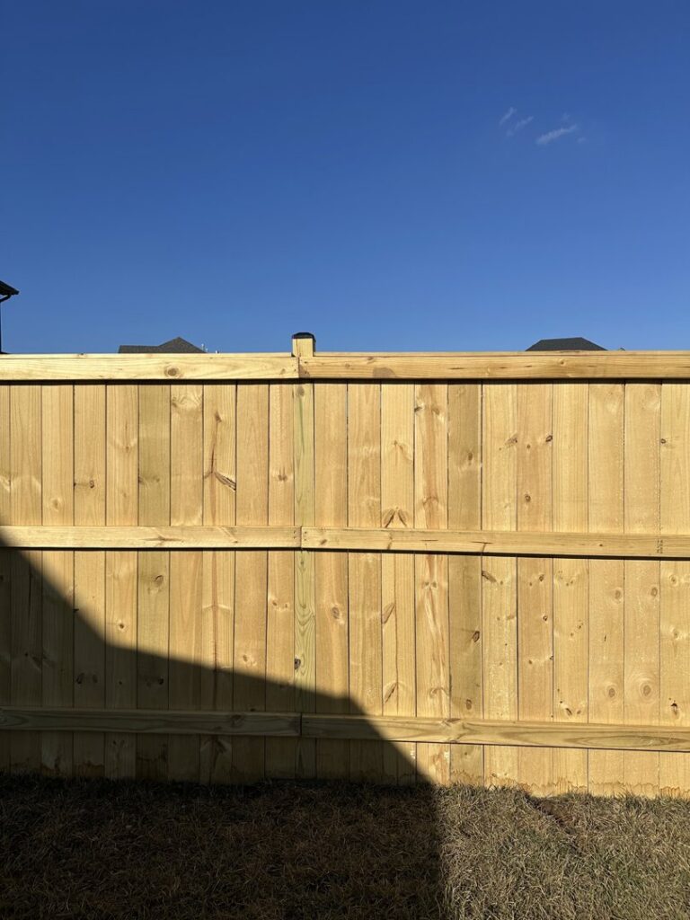 A close-up view of a newly installed wooden privacy fence, highlighting the craftsmanship of Roark Fencing in Lexington, KY.