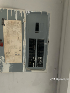 A closed electrical breaker panel with a main breaker and circuits, serviced by The Panel Pal in Bethlehem, GA.