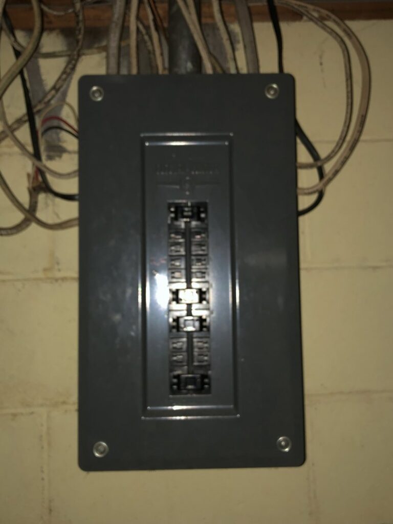 A closed electrical panel (breaker box) installed on a wall with visible wiring, showing work by Affordable Electric, LLC in Kearney, NE.