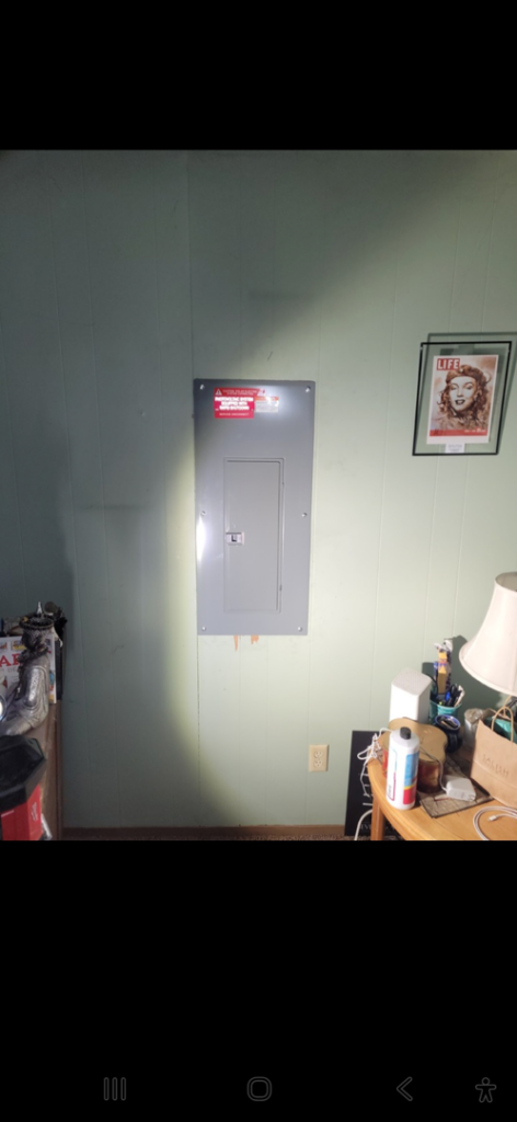 A newly installed closed electrical panel on a wall, completed by ANT POWER LLC in Tacoma, WA.