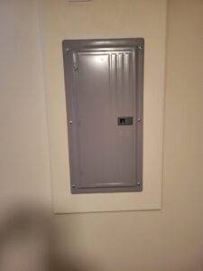 A closed electrical panel installed on an interior wall by Interstate Electrical Contractors in Dalton Gardens, ID.