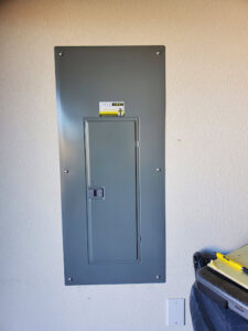 A closed electrical panel with the True Light Electric logo sticker in Albuquerque, NM.