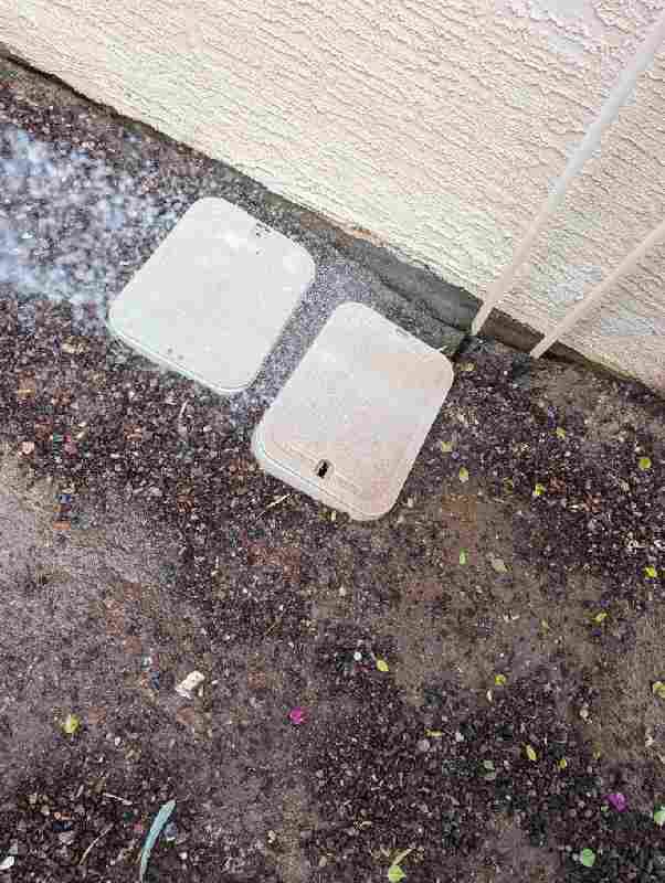Two closed pest bait stations placed discreetly next to a house wall, used for rodent control by Bernard's Pest in Glendale, AZ.