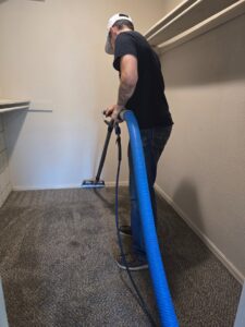 A carpet cleaning technician from CleanWater Restoration cleaning carpet inside a closet in Edmond, OK.