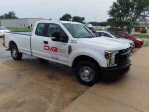 A white CM3, Inc. HVAC pickup truck parked on a commercial job site in Wichita, KS.