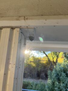 Close-up of thick cobwebs on a window frame, indicating a spider problem that Peak Pest Control can resolve in Ogden, UT.