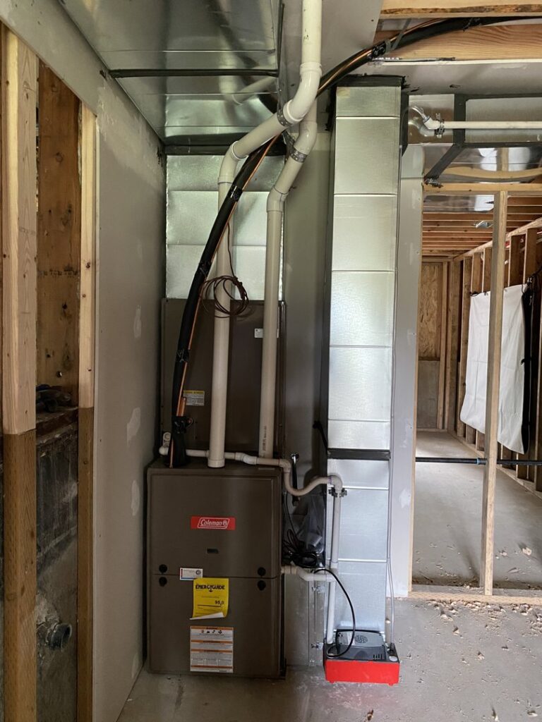 An indoor Coleman furnace and air handler with ductwork installed during a new construction project by Climate Control Experts HVAC LLC in Federal Way, WA