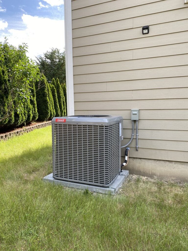 A Coleman outdoor HVAC unit professionally installed next to a residential building by Climate Control Experts HVAC LLC in Federal Way, WA
