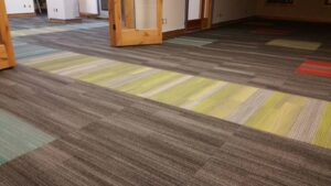 Colorful carpet tile installation in progress, showcasing a job by Bozeman Flooring in Bozeman, MT.