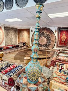 A vibrant display of colorful Persian rugs and decorative items in the Art Of Persia showroom in Portland, OR.