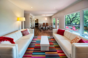 A modern living room featuring a vibrant, colorful striped area rug installed by Carpet Mill and Distributors Inc in Tucson, AZ.