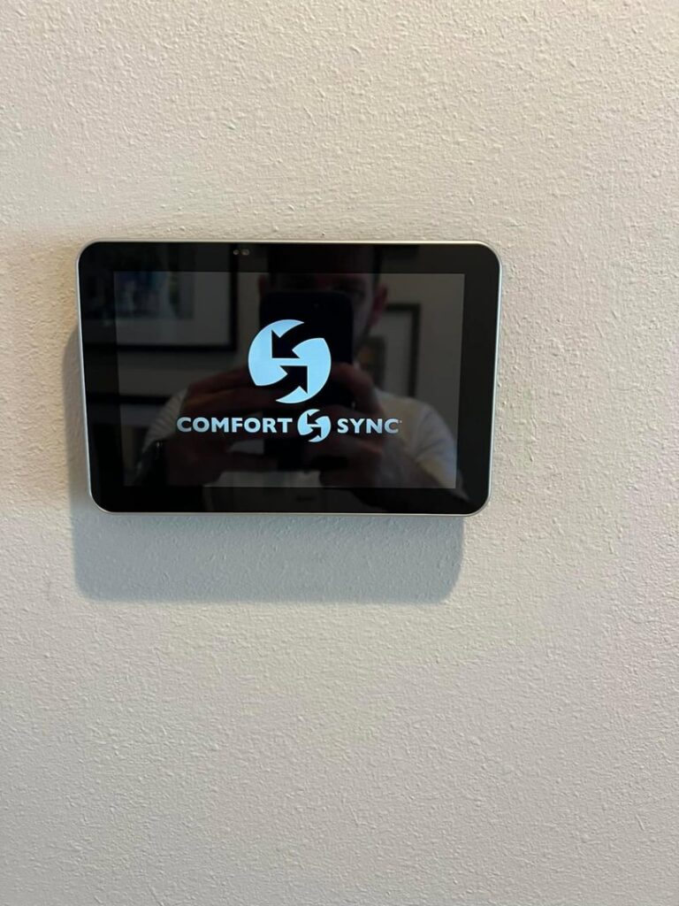 A Comfort Sync smart thermostat installed on a wall by Comfort Zone AC and Heating Services LLC in Sunrise Beach, MO