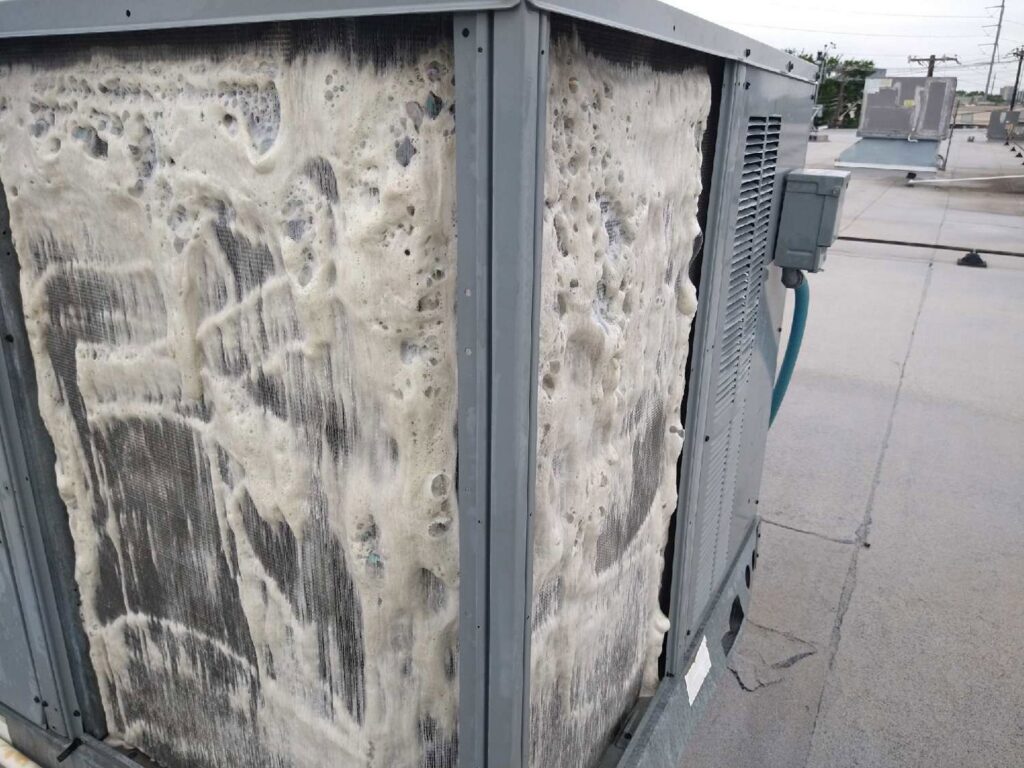 Outdoor commercial AC unit undergoing coil cleaning with foam by Benavidez Heating & Air Conditioning In, Arlington, TX.