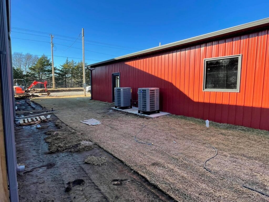 Two outdoor commercial AC units installed by Chapman HVAC next to a red building in Cleveland, OK.