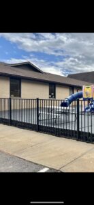 A black aluminum fence securing a commercial playground area, installed by Cavitt Fencing in Concord, NC.