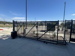 A commercial automatic black metal sliding gate installed by Iron Fence Services, LLC in Lancaster, TX.