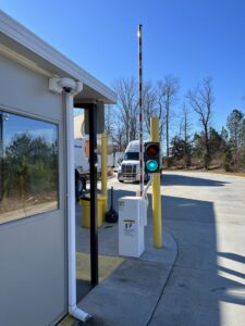 A commercial barrier arm gate with a traffic light and guard booth for access control by Gates Contractors in White, GA.
