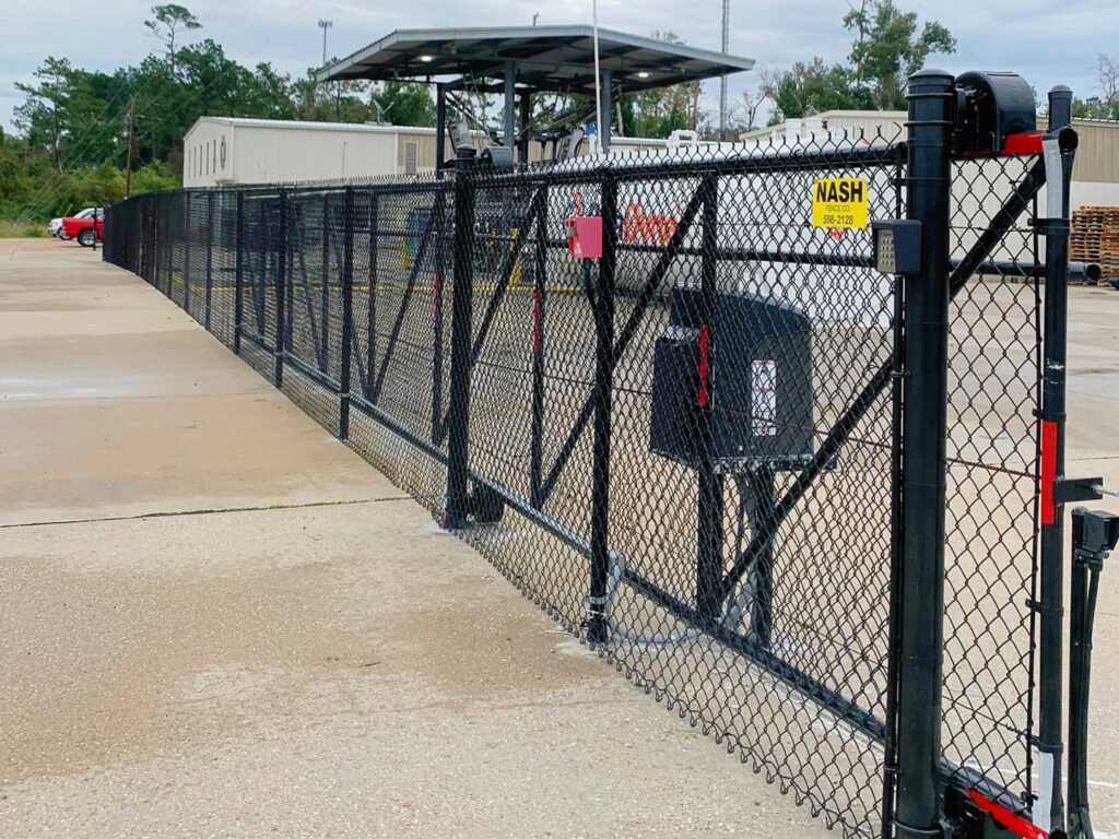 A commercial black chain-link fence with an automated gate system by Nash Fence & Supplies Inc. in Lake Charles, LA.