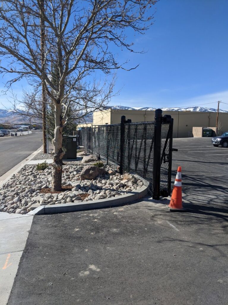 A commercial black chain-link fence with a large gate for property security by Finest Fence in Simi Valley, CA.