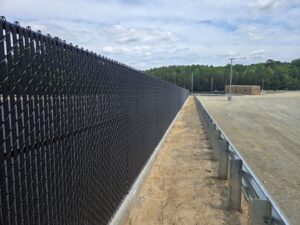 A long commercial black chain-link fence with privacy slats, installed by Superior Fence & Rail Richmond, VA.