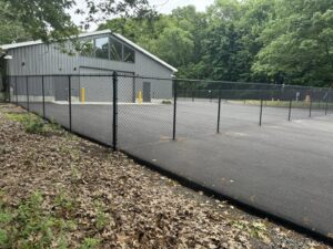 A commercial black chain link fence installed around a building by Select Fence & Guardrail in North Haven, CT.