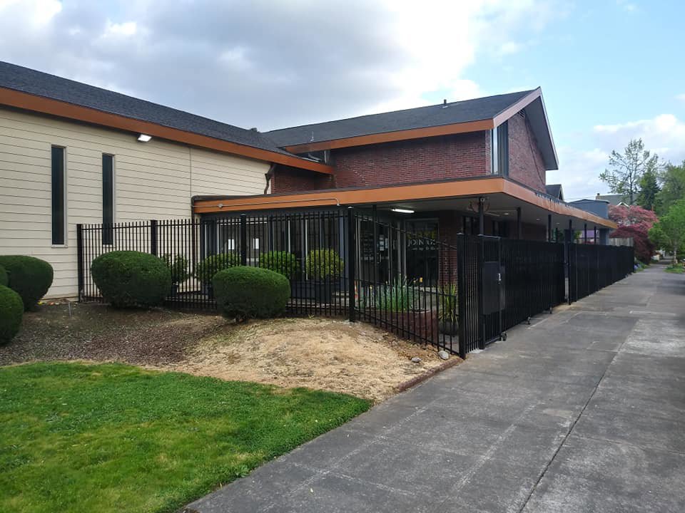 A commercial black ornamental iron fence installed by Stewart & Son Gate & Fence Co. in Hillsboro, OR