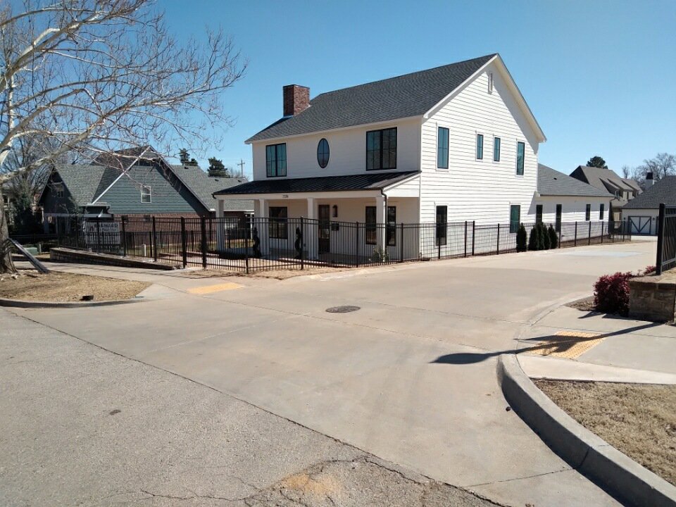 A black metal fence installed around a commercial or multi-unit residential building by Frontline Fence Company in Fulton, NY