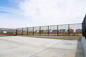 A black metal fence and gate installed in a commercial or industrial area by Competitive Fence Contractors LLC in Scottsdale, AZ.