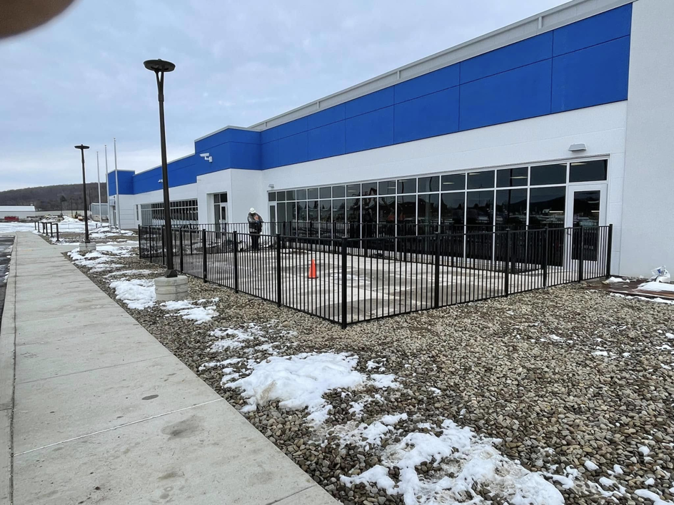 A commercial black ornamental metal fence installed around a business property by STILL Fencing in Rochester, NY.