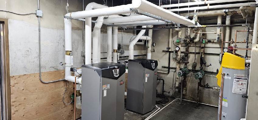 A commercial boiler room with multiple large units and complex piping, serviced by Encode Corporation in Billings, MT.