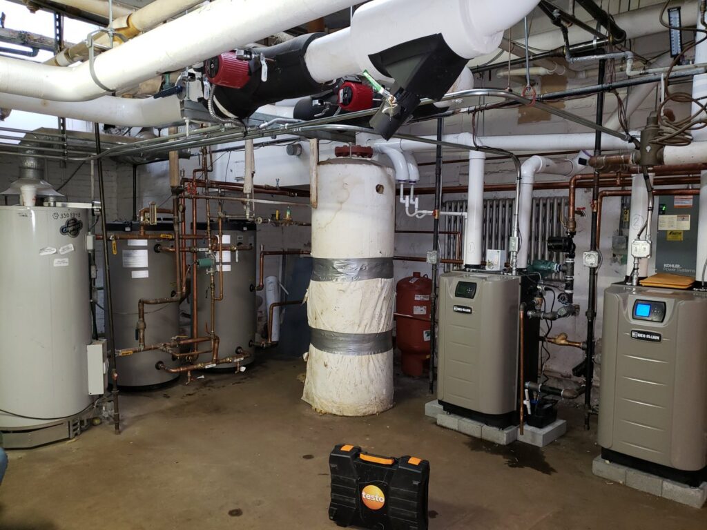 A commercial boiler room installation with multiple heating units by Synergy3, an HVAC contractor in Philadelphia, PA.