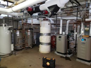A commercial boiler room installation with multiple heating units by Synergy3, an HVAC contractor in Philadelphia, PA.