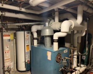 A commercial boiler and multiple water heaters with complex piping installed by 9-1-1 Heating & Air, LLC in Milwaukee, WI.