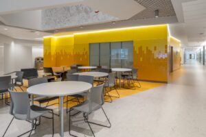 A commercial breakroom with modern vinyl flooring and yellow accents installed by Capital Carpet & Flooring Specialists in Wilmington, MA