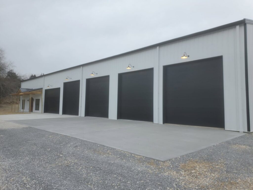 A commercial building featuring multiple black garage doors installed by 314 Overhead Doors in O'Fallon, MO.
